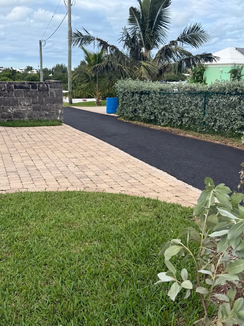 Finished asphalt driveway meeting a paver forecourt