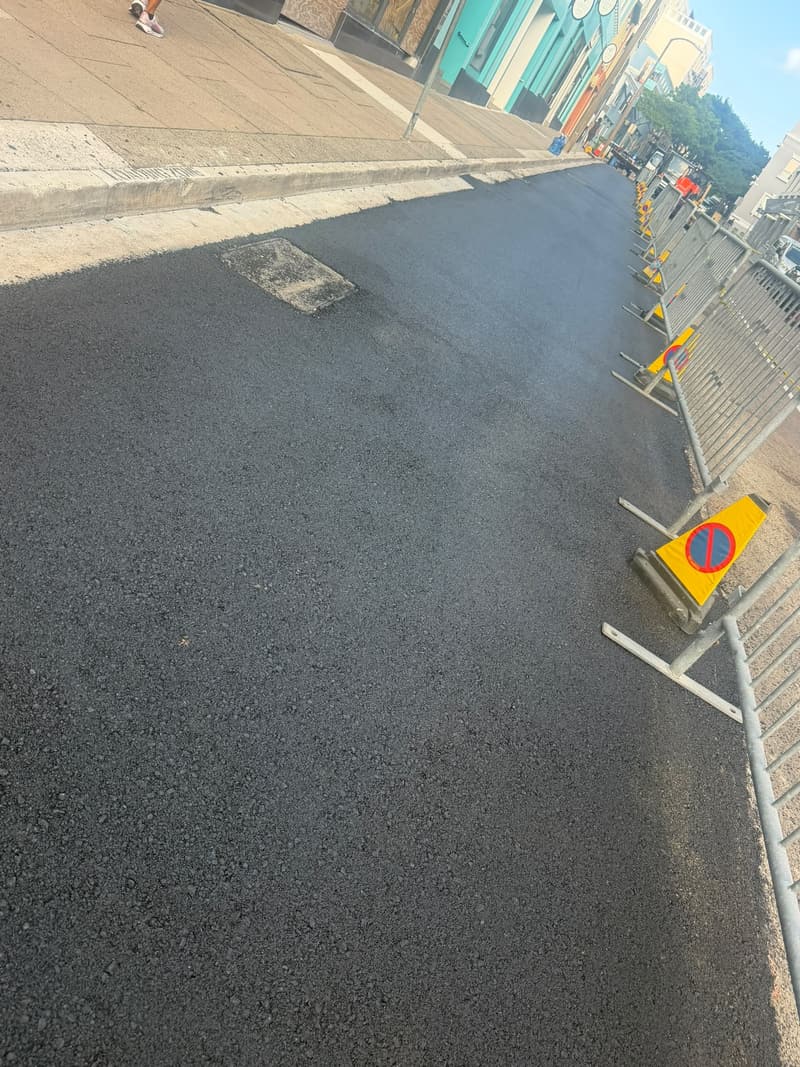 Milling machine and crew removing worn asphalt along a street in Hamilton