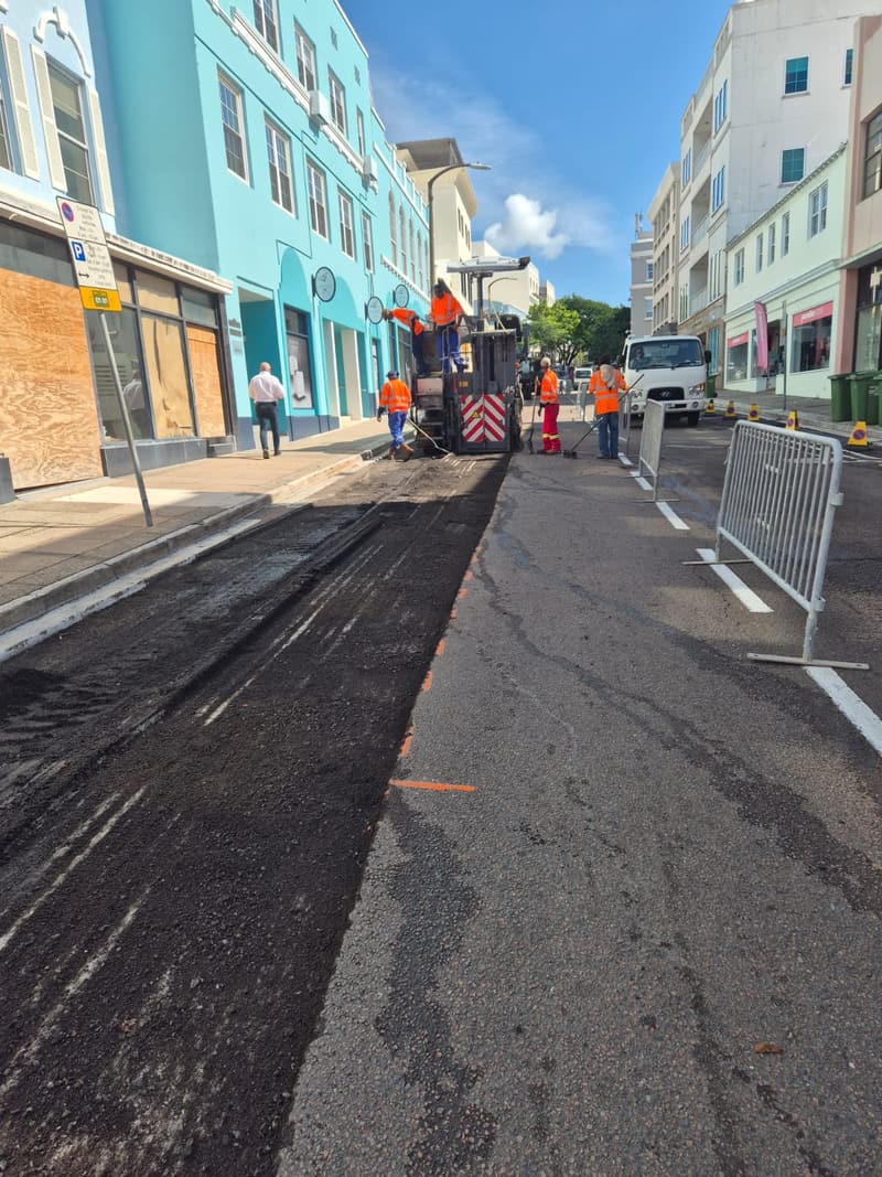Freshly resurfaced asphalt lane along a Hamilton street, with barriers in place