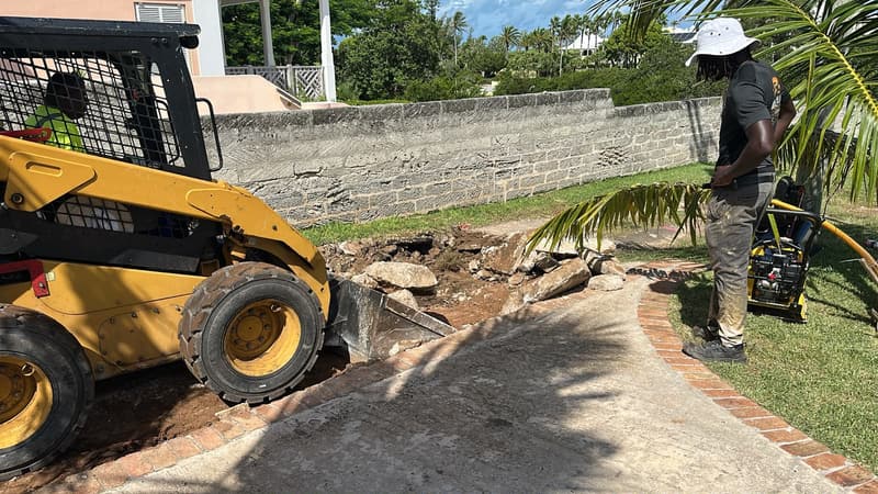Quality Control skid steer clearing broken material on a residential site