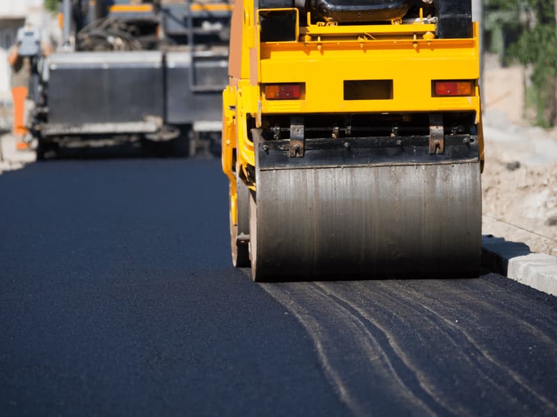 Roller compacting a fresh asphalt surface on a street