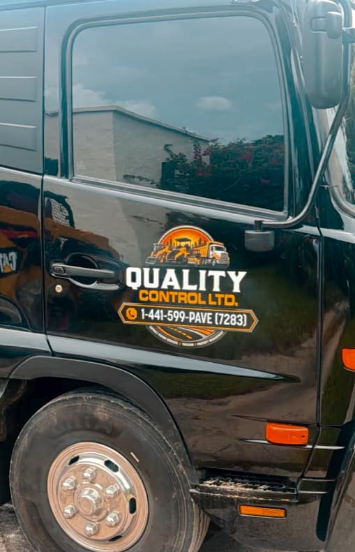 Door of a Quality Control Ltd truck showing the company logo and phone number